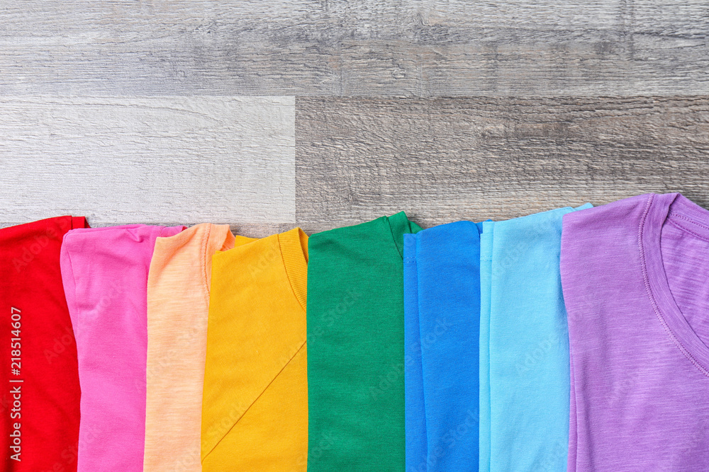 Colorful collection of t-shirts on wooden background