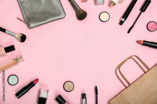 Flat lay composition with shopping bag and cosmetics on color background