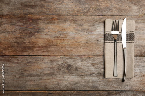 Cutlery and napkin on wooden background, top view. Table setting