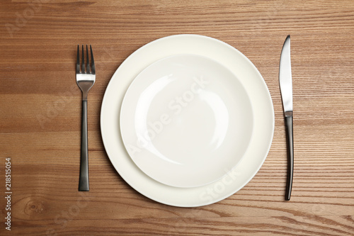 Empty dishware and cutlery on wooden background  top view. Table setting