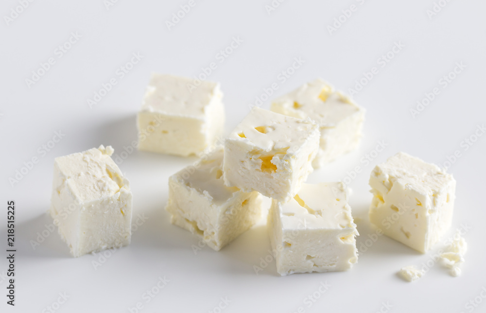 Feta cheese cubes on white background with space for text