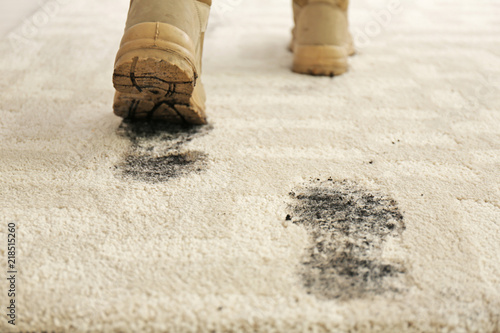 Cuadro en lienzo Person in dirty shoes leaving muddy footprints on carpet