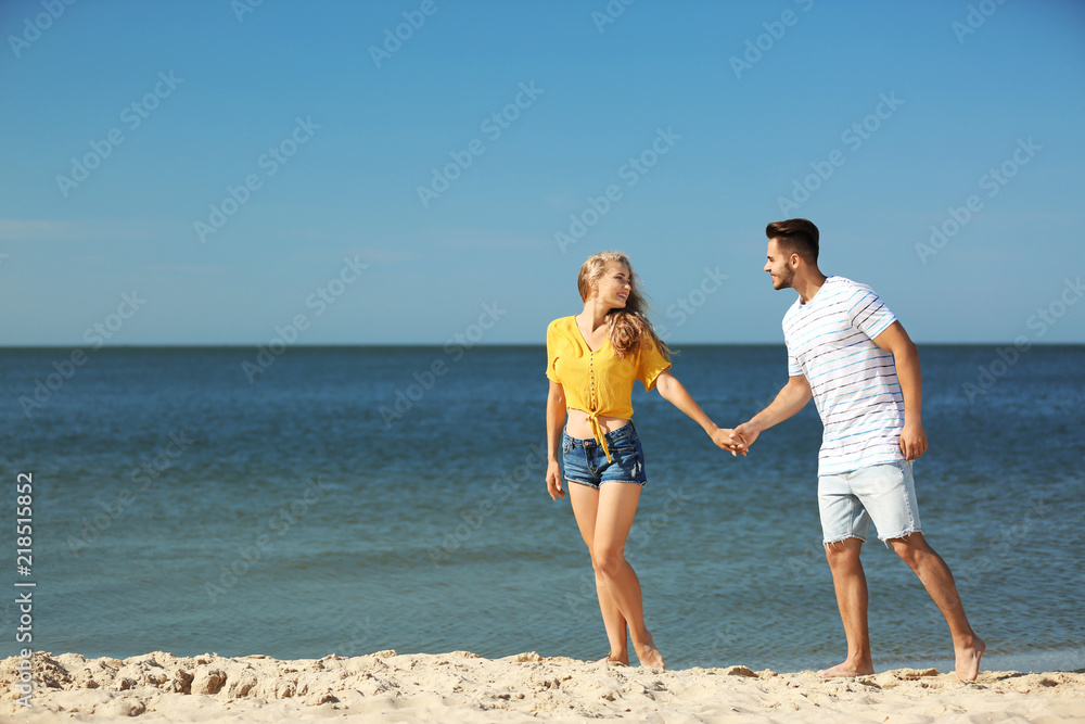Happy young couple at beach on sunny day Happy young couple at beach on sunny day