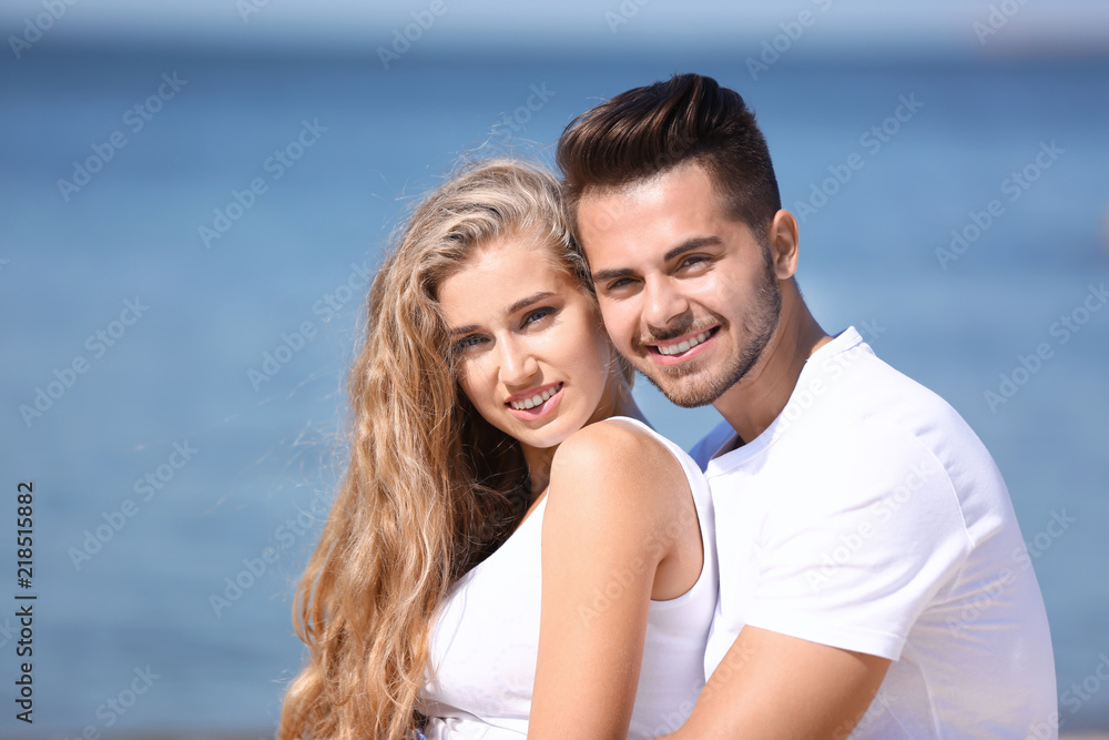 Happy young couple at beach on sunny day Happy young couple at beach on sunny day