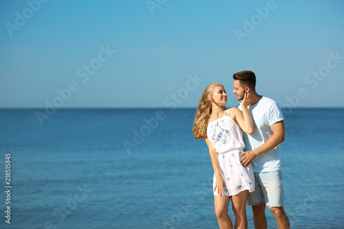 Happy young couple at beach on sunny day