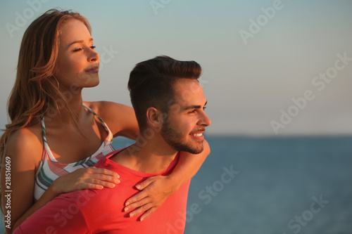 Happy young couple playing together on beach