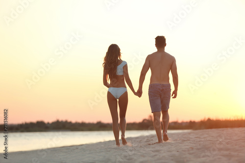 Fototapeta Naklejka Na Ścianę i Meble -  Happy young couple walking together on beach