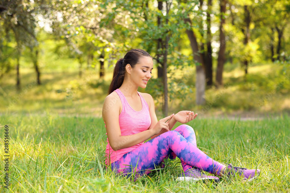 Young woman checking pulse outdoors on sunny day Young woman checking pulse outdoors on sunny day