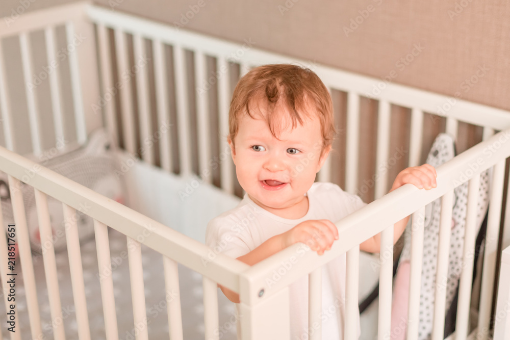 Cute little baby boy looking out of his bed Cute little baby boy looking out of his bed