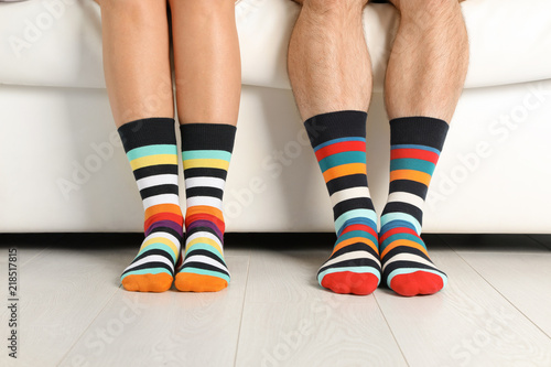 Young couple in matching socks on couch indoors, closeup