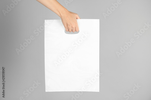 Woman with plastic bag on grey background. Mock up for design