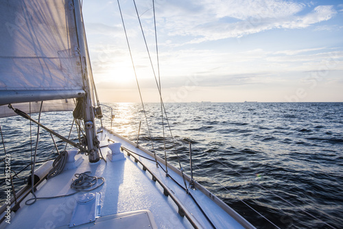Sailing at sunset. A view from the yacht's deck to the bow and sails. Baltic sea, Latvia © Aastels