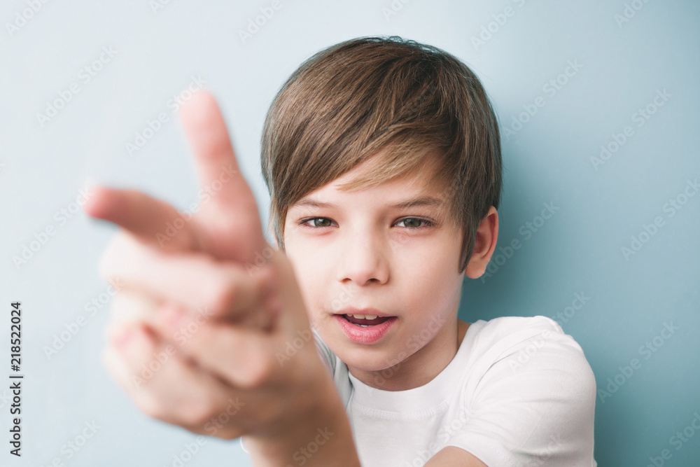 Boy jokingly portrays shot from fingers into camera Boy jokingly portrays shot from fingers into camera