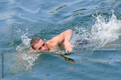 young man swims in the sea, close-up