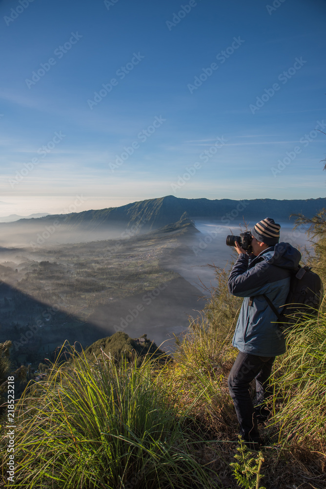A man traveler with shooting photo amazing nature near of Mount BROMO at indonesia A man traveler with shooting photo amazing nature near of Mount BROMO at indonesia