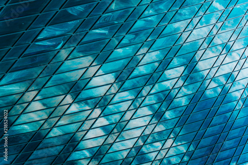 Geometry and lines of a modern business center. Clouds are reflected in the glass windows of a high-rise skyscraper of a modern commercial city of the future