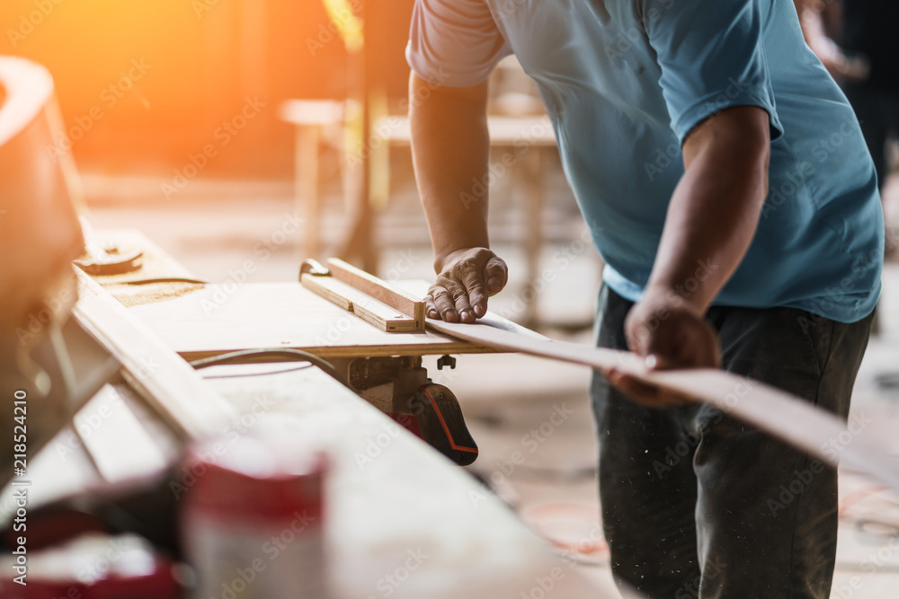 Fototapeta premium closeup carpenter hand work with sawing wood plank site conctruction background concept