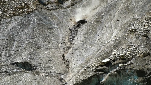 Slow motion rockfall in the mountains close up. Lumps of stones fall down from the melting glacier