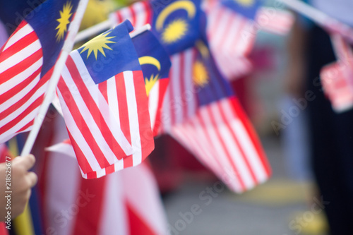 Hand waving Malaysia flag also known as Jalur Gemilang in conjunction with the Independence Day celebration or Merdeka Day. photo