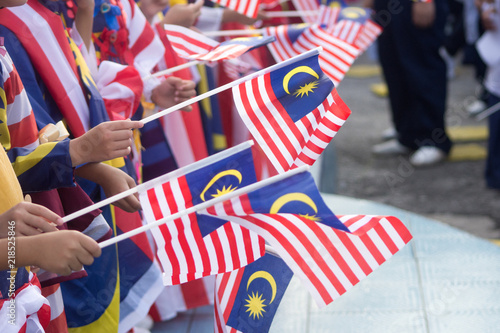 Hand waving Malaysia flag also known as Jalur Gemilang in conjunction with the Independence Day celebration or Merdeka Day.
