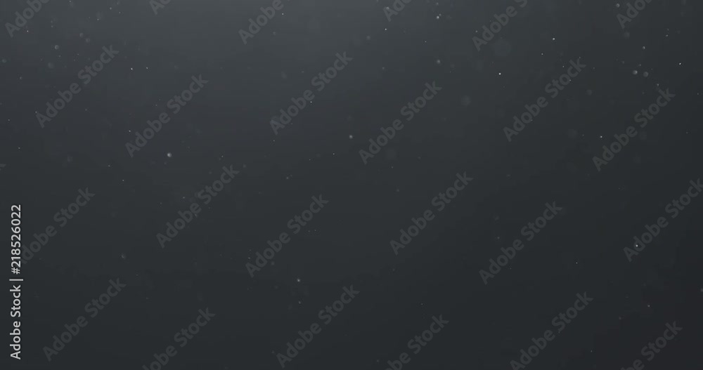 Slow motion real dust floating in air over dark background Slow motion real dust floating in air over dark background