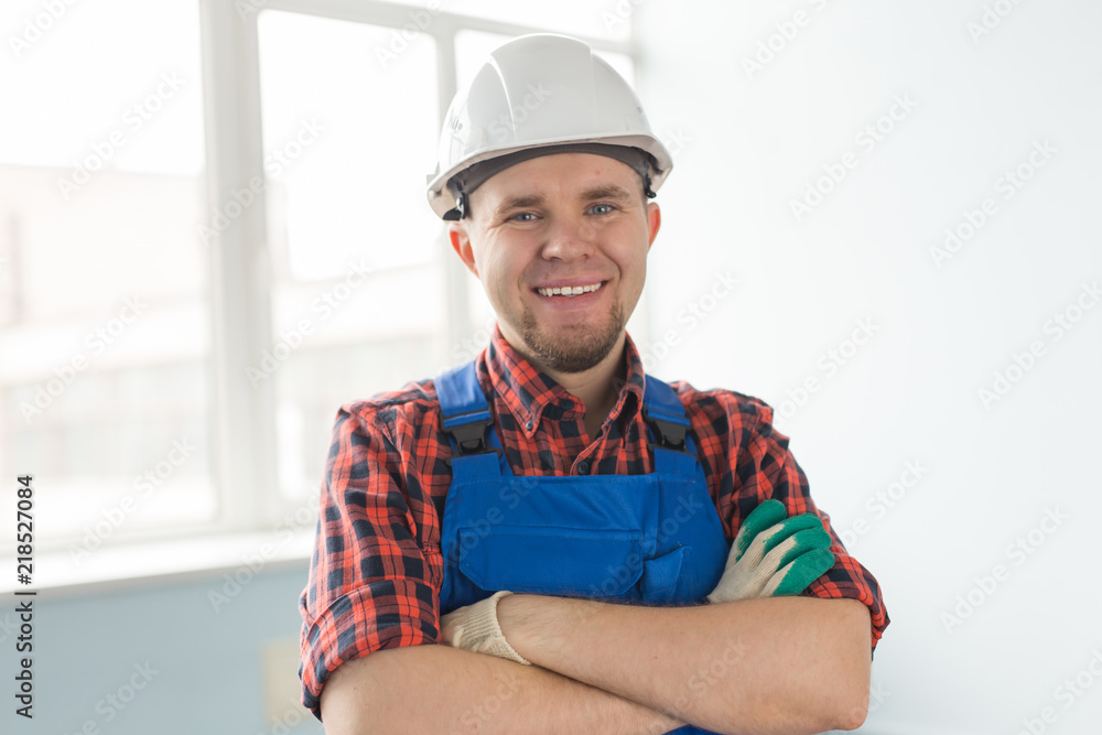 Close up of happy caucasian male builder with crossed hands wearing white helmet Close up of happy caucasian male builder with crossed hands wearing white helmet
