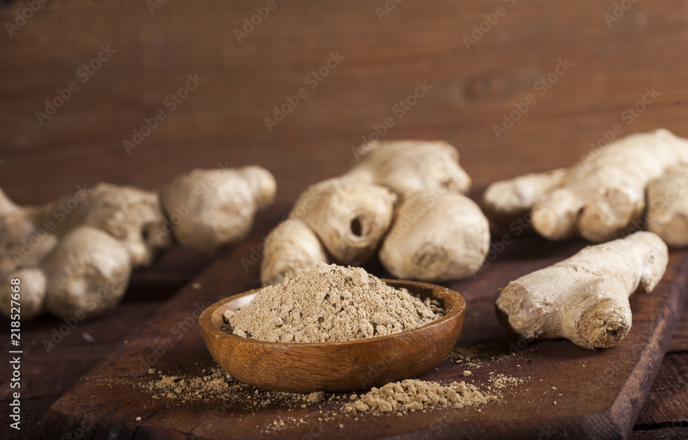 Ginger root and ginger powder on wooden background Ginger root and ginger powder on wooden background