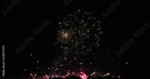 Festive fireworks in the black sky. Large fireworks of different colors. Real colorful fireworks at holiday night. 