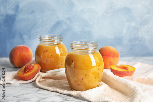 Tasty peach smoothie in glass jars on table