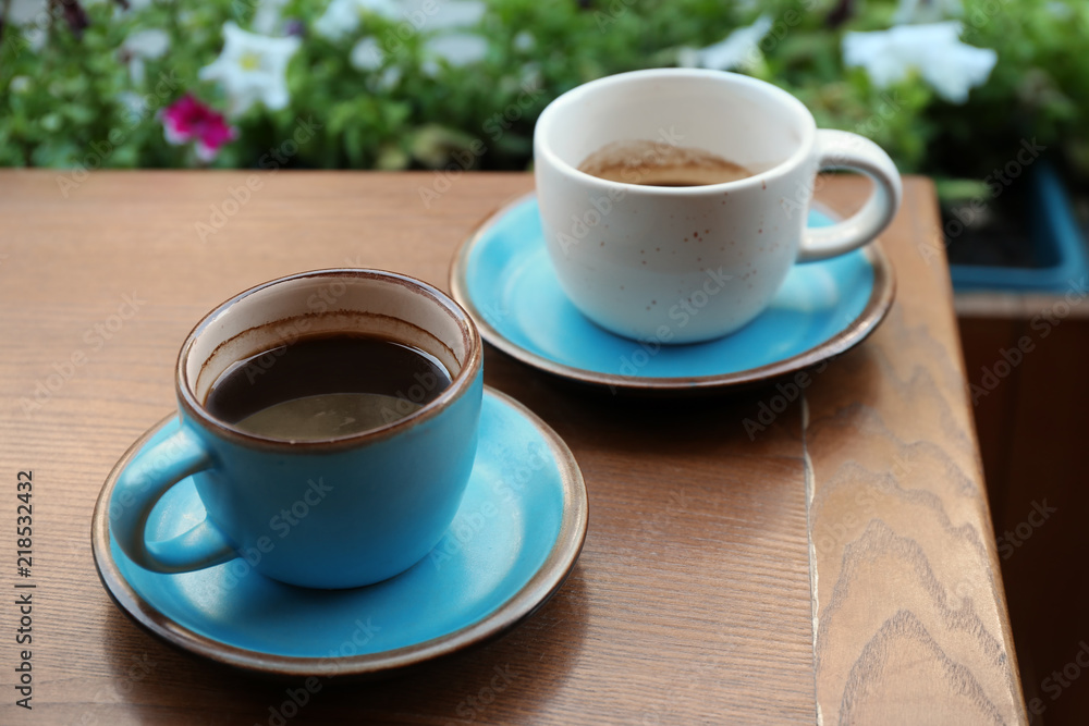 Cups of fresh aromatic coffee on wooden table Cups of fresh aromatic coffee on wooden table