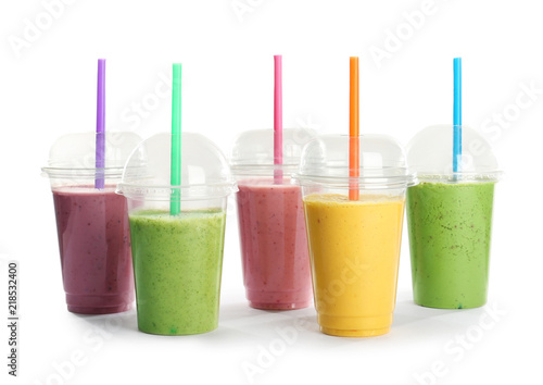 Plastic cups with fresh tasty smoothies on white background