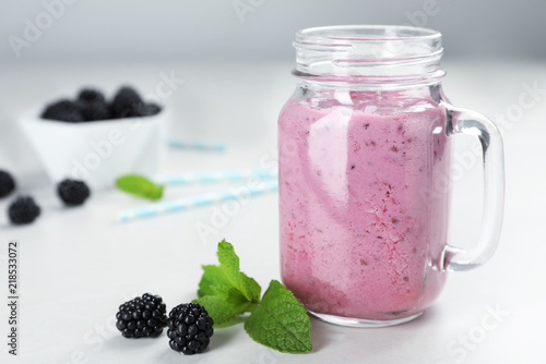 Mason jar with blackberry yogurt smoothie on table