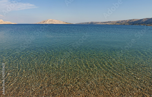 Croazia: l'acqua cristallina di Rucica, la spiaggia di ciottoli in una baia brulla circondata da un paesaggio desertico a sudest del villaggio di Metajna, sull'isola di Pago photo