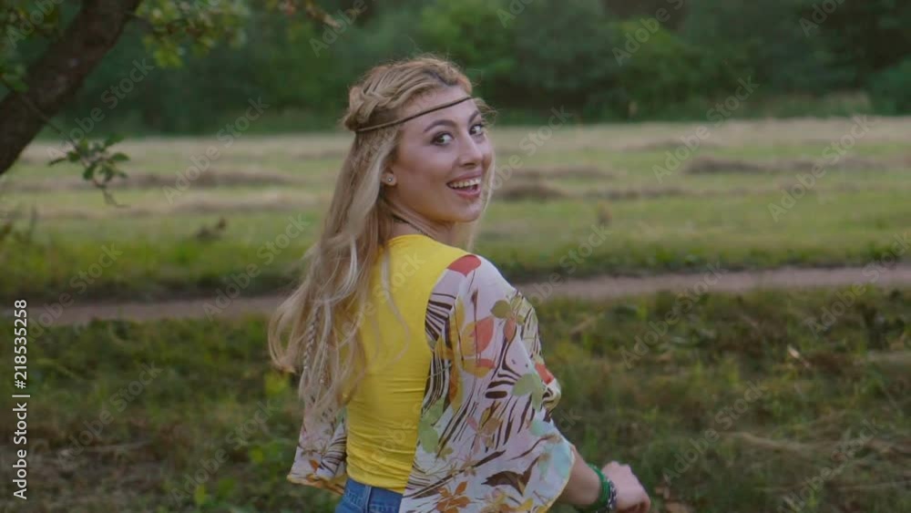 portrait of a young blonde woman with hippies. a woman with braided hair lies and rests on the grass garden. Warm spring day and soft backlight. happy woman is relaxing in nature. the middle plan portrait of a young blonde woman with hippies. a woman with braided hair lies and rests on the grass garden. Warm spring day and soft backlight. happy woman is relaxing in nature. the middle plan