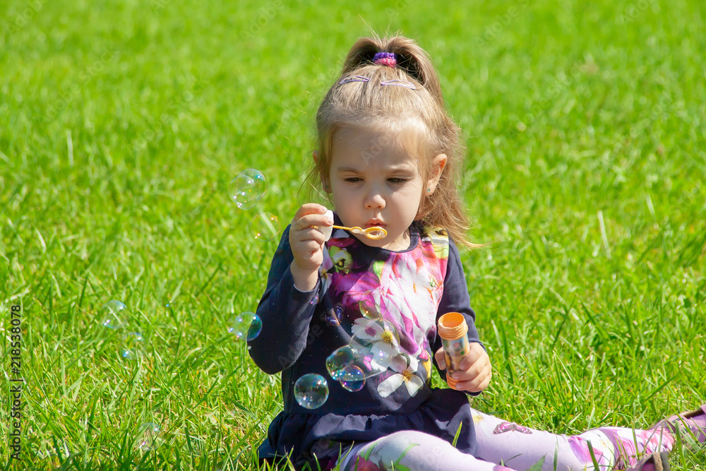 the little girl starts up soap bubbles in the park the little girl starts up soap bubbles in the park