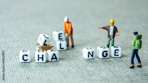 Removing white cubes with letters l and e of the word challenge creating new word change on grey background with miniature figurines photo
