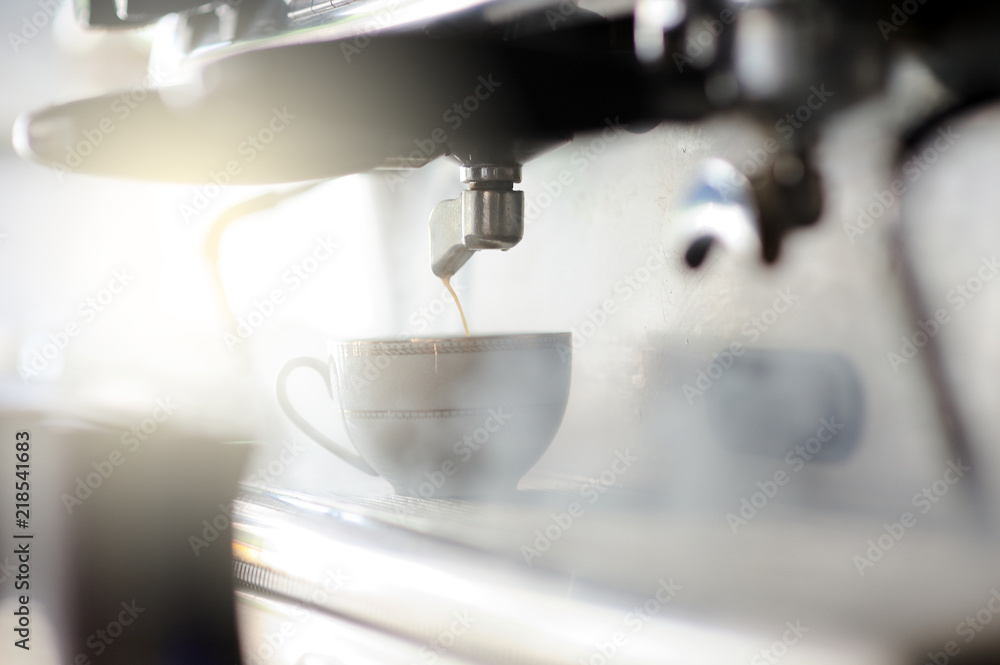 Barista making a espresso with a classic Italian coffee machine with steam in background. Barista making a espresso with a classic Italian coffee machine with steam in background.