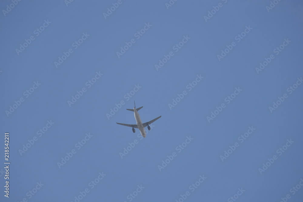 A airplane flies through the blue and cloudless sky. A airplane flies through the blue and cloudless sky.