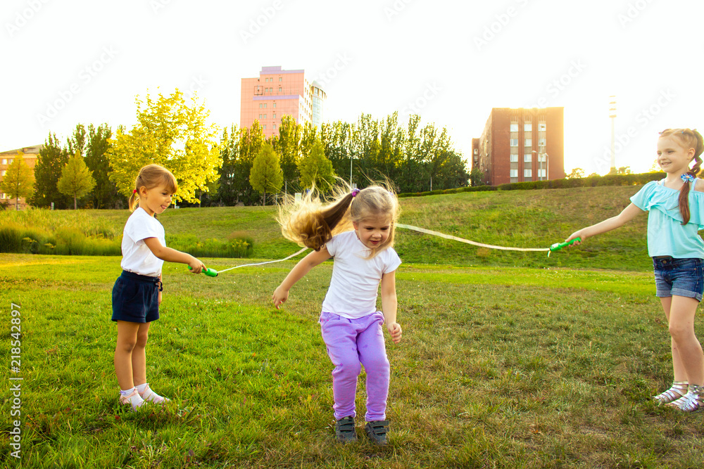 Obraz premium three cheerful girls are played with a rope