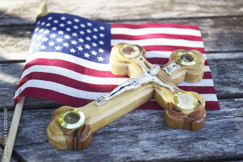 American flag with cross on wooden surface