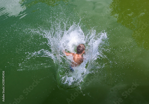 Junge springt in See, Wasser spritzt