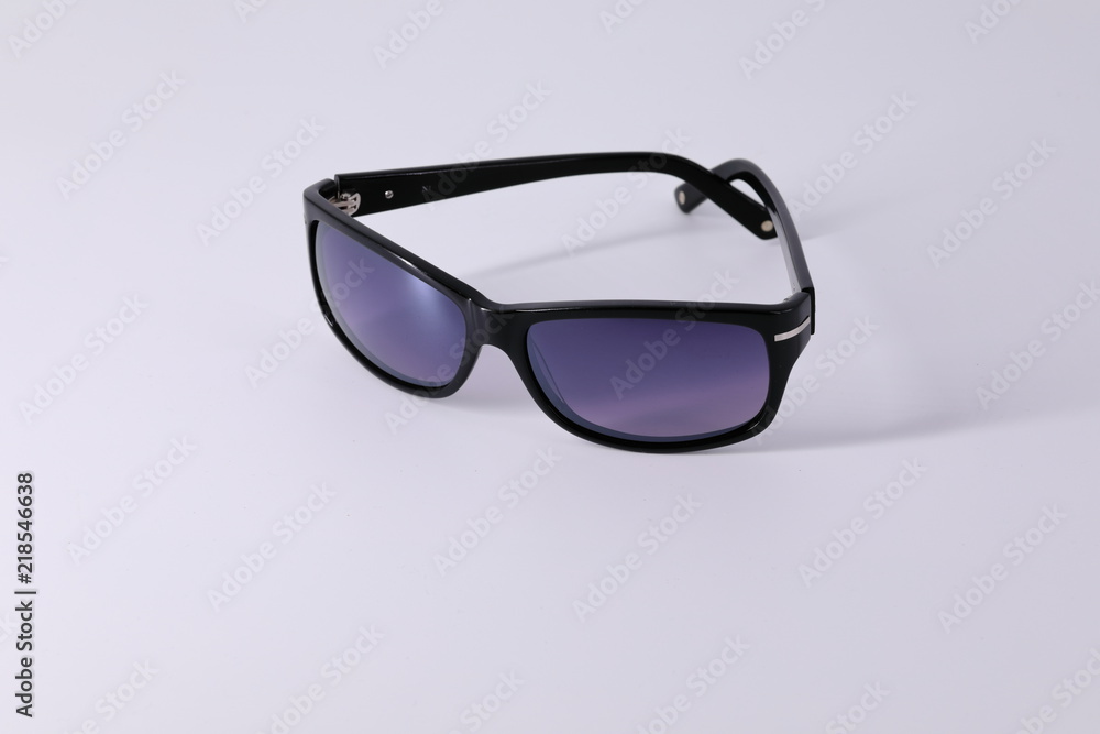 Sunglasses made of dark material and dark glasses, subject shooting on a light background. Sunglasses made of dark material and dark glasses, subject shooting on a light background.