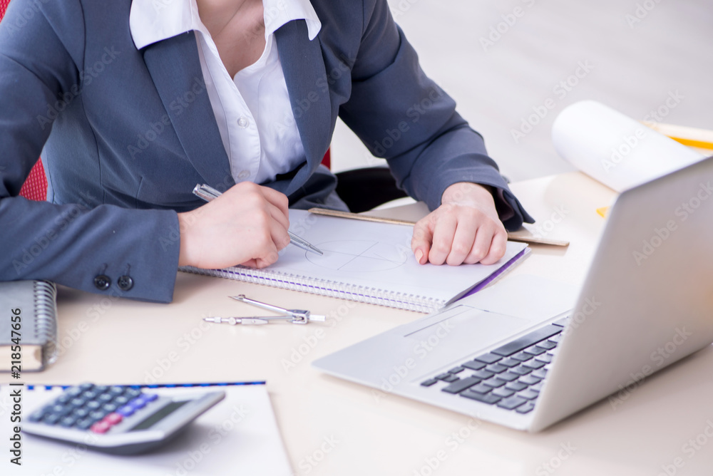 Female finance professional working on keyboard with reports Female finance professional working on keyboard with reports