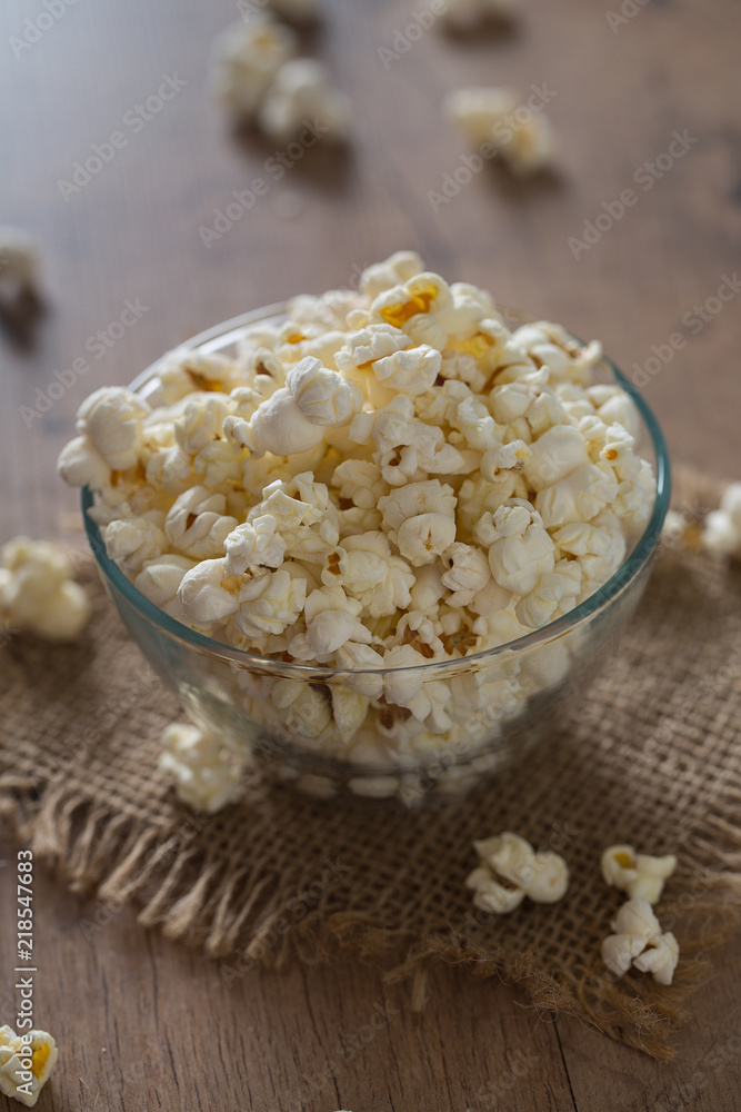 bowl of popcorn on wooden surface bowl of popcorn on wooden surface