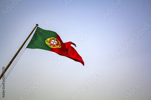 Portuguese flag waving against blue sky