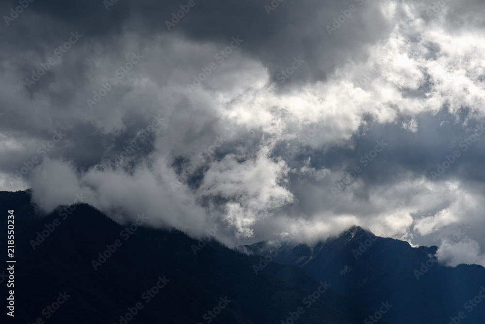 Sun rays peak through dramatic clouds over St Mary Lake in Kimberley, Canada