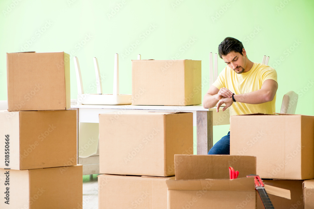 Young handsome man moving in to new house with boxes Young handsome man moving in to new house with boxes