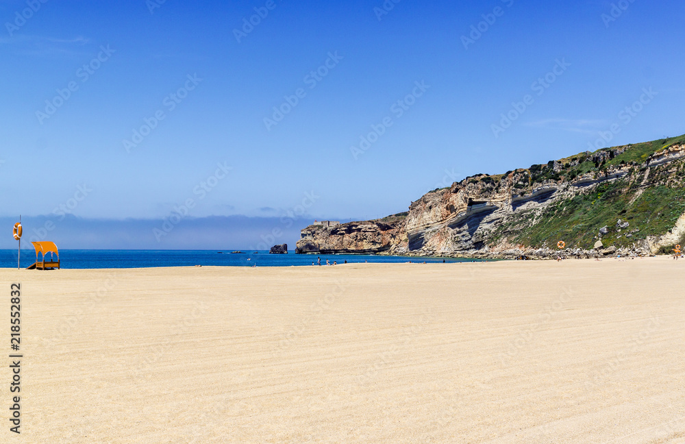 The beach of Nazare, Portugal. A small Portuguese town on the Atlantic coast. Rocks and sea.