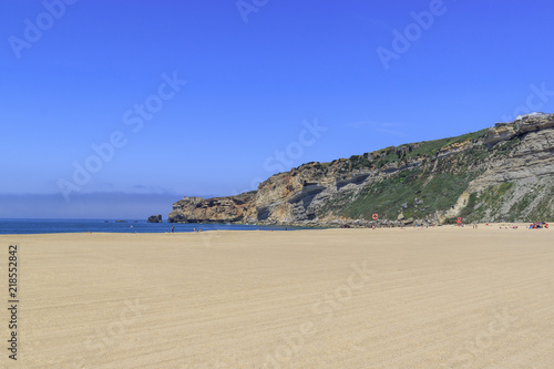 The beach of Nazare, Portugal. A small Portuguese town on the Atlantic coast. Rocks and sea.