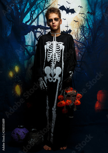 cute  young boy with black make up in the skeleton costume. preparation to Halloween  costume party.
